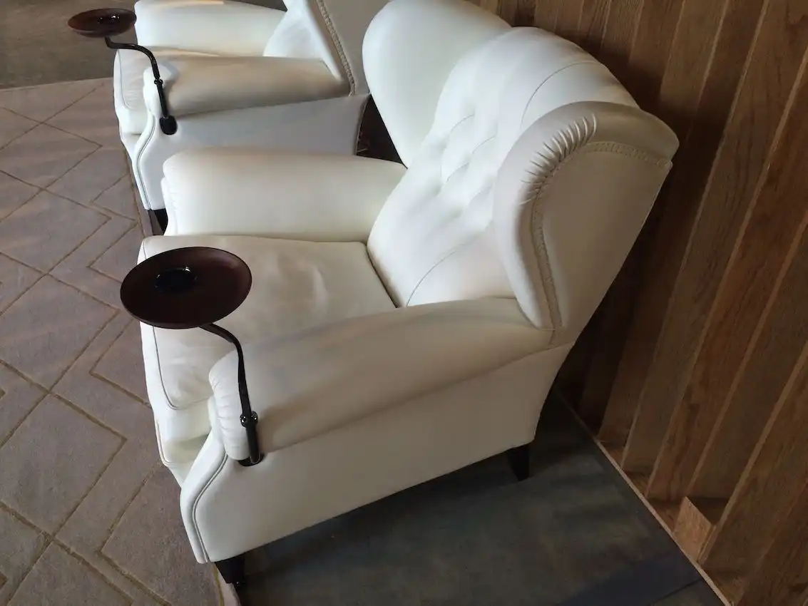 A Chesterfield style chair from Poltrona Frau includes a small table.
