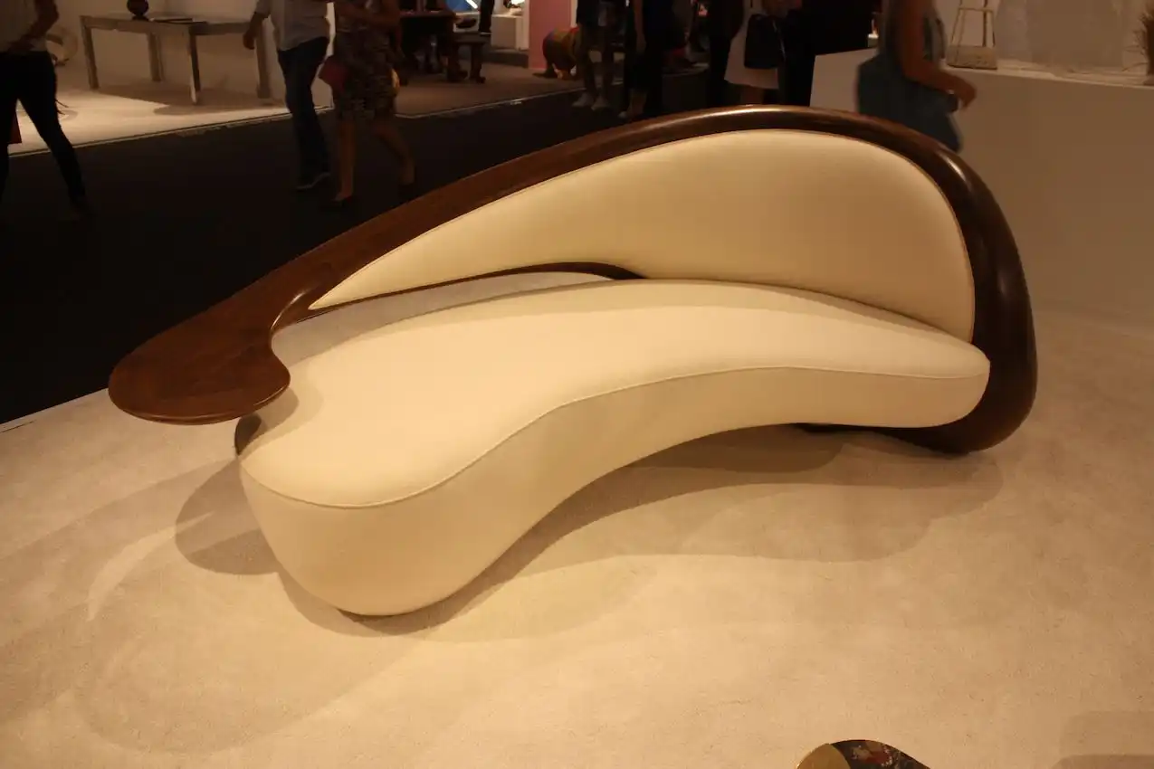 The sofa is mad from American walnut wood and upholstered in boiled wool.