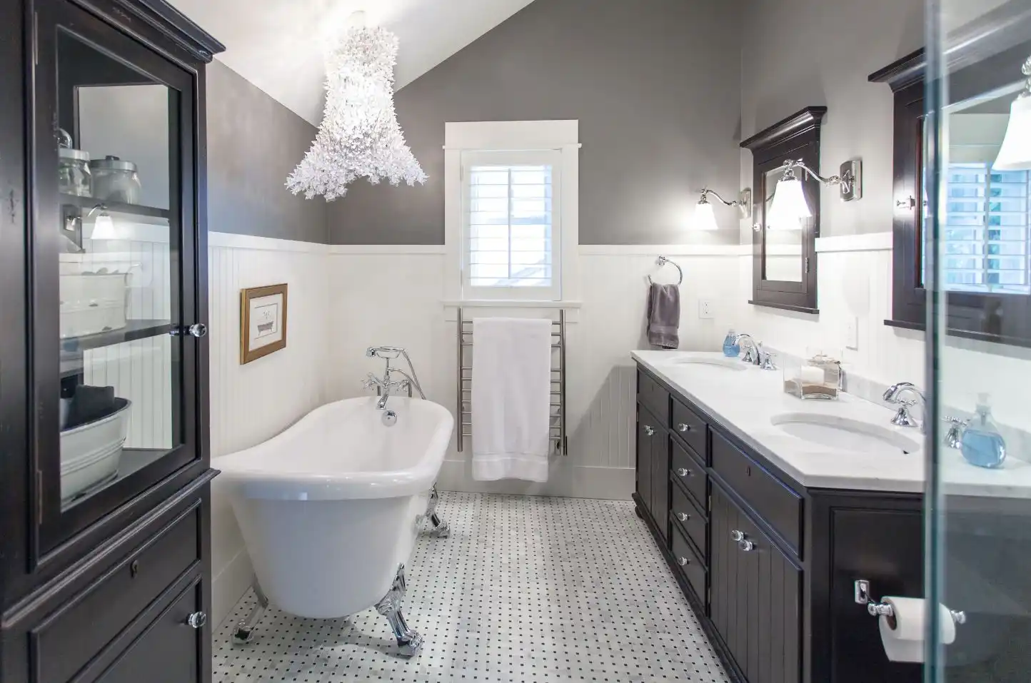 Bahtroom with beadboard and chandelier over bathtub