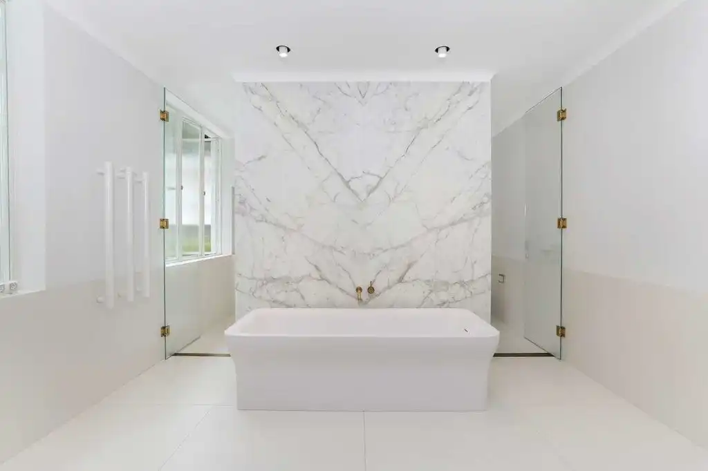 Bathroom with large marble wall and walk in shower