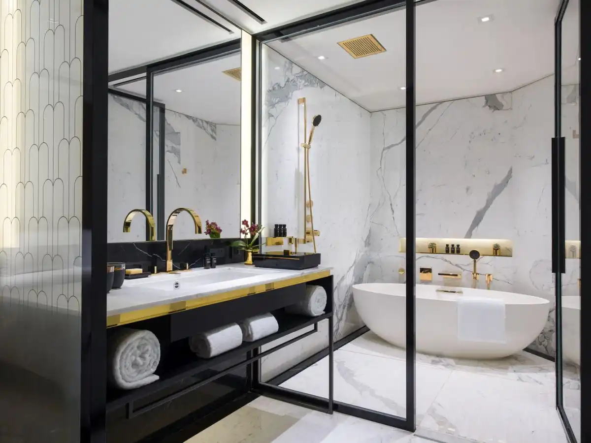 Bathroom with marble walls and gold fixtures