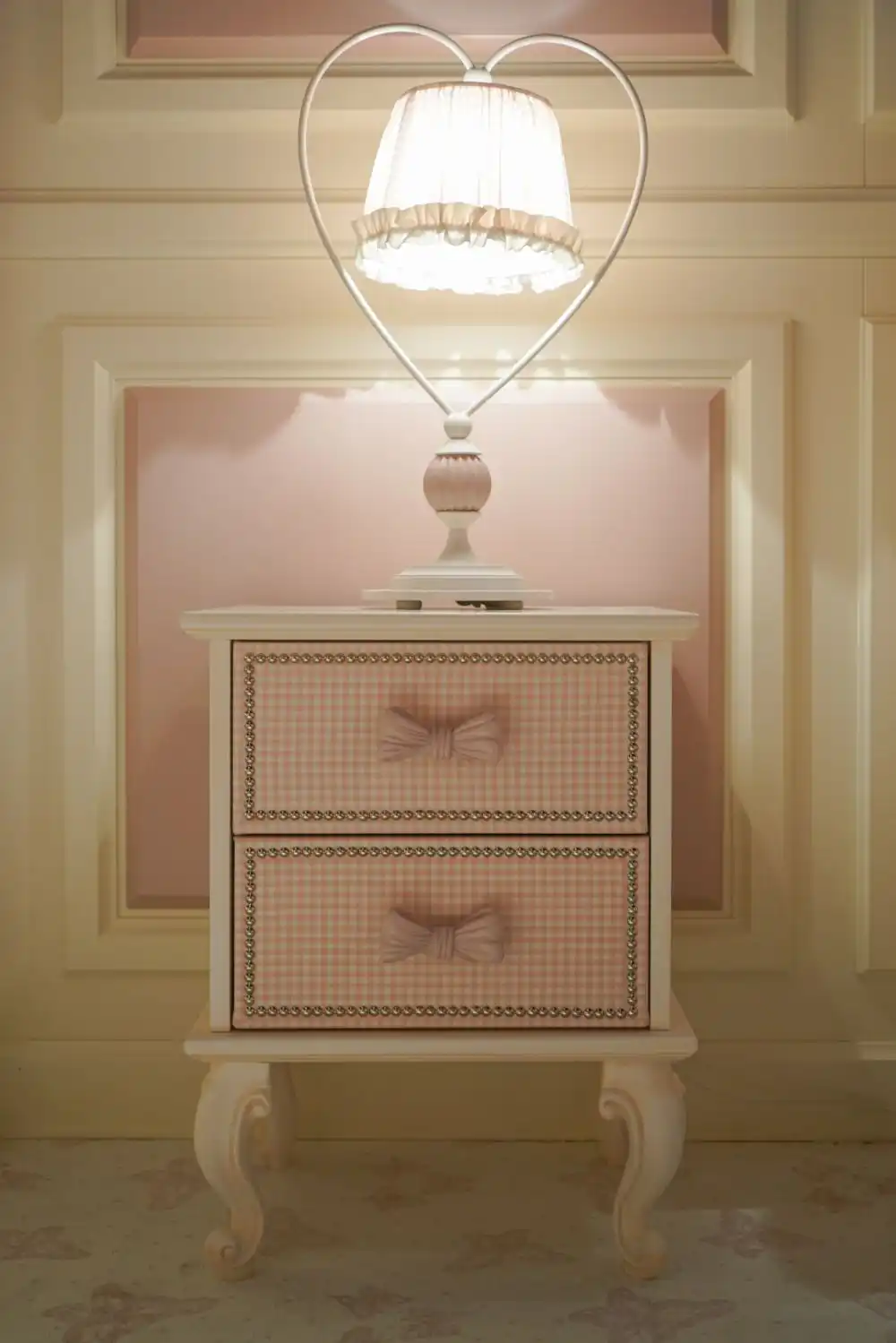 This cute little nightstand is exquisite, with its fabric-covered drawer fronts, the trim and the bow pulls