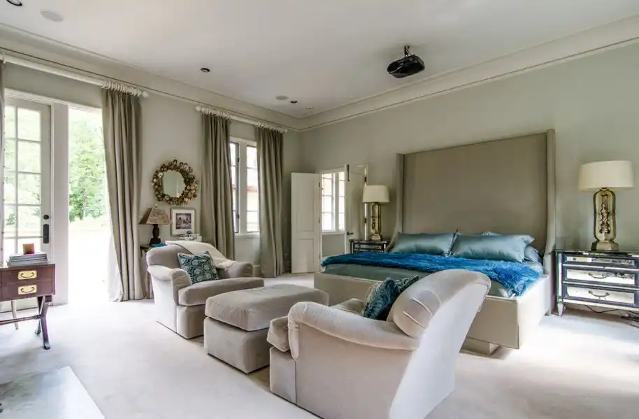 Bedroom featuring a high bed headboard and mirrored nightstands