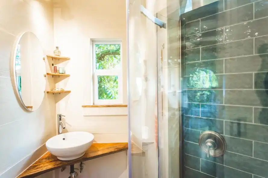 Tiny house bathroom with shower and niches. corner Sink