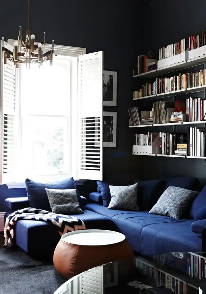 Black walls living room and blue sofa