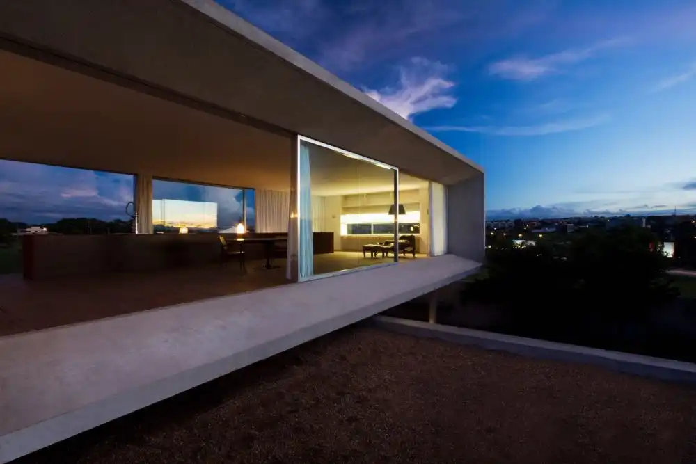 The concrete shell of the top volume extends around it forming a sort of protective edge