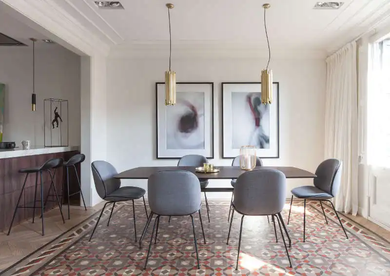 Contemporary dining room with modern chairs gold pendants and abstract wall art