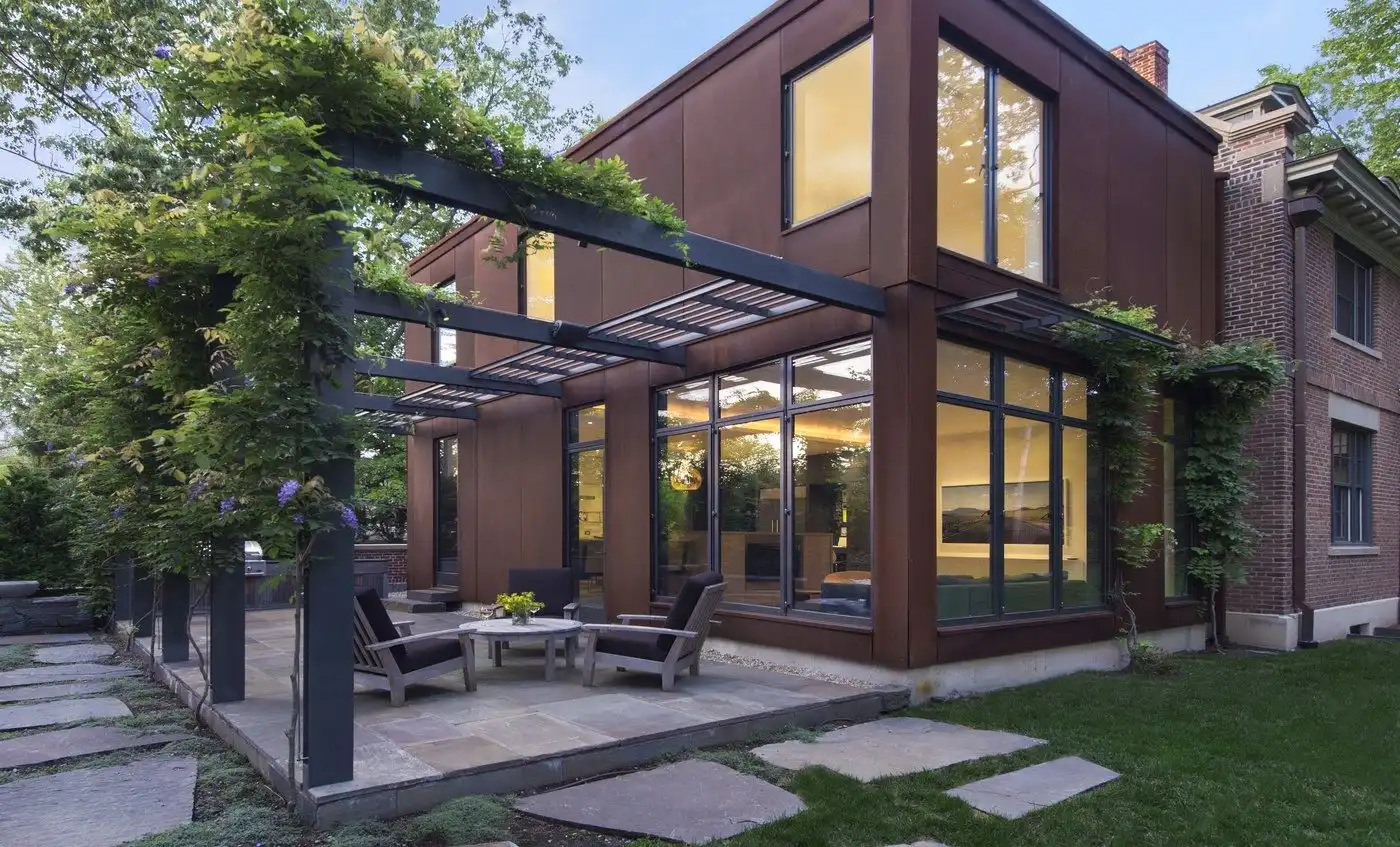 Corten steel house facade with pergola and hanging plants