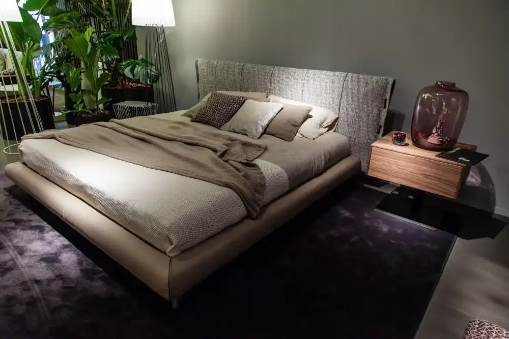 Cream bed design with wood bedside table on a leg