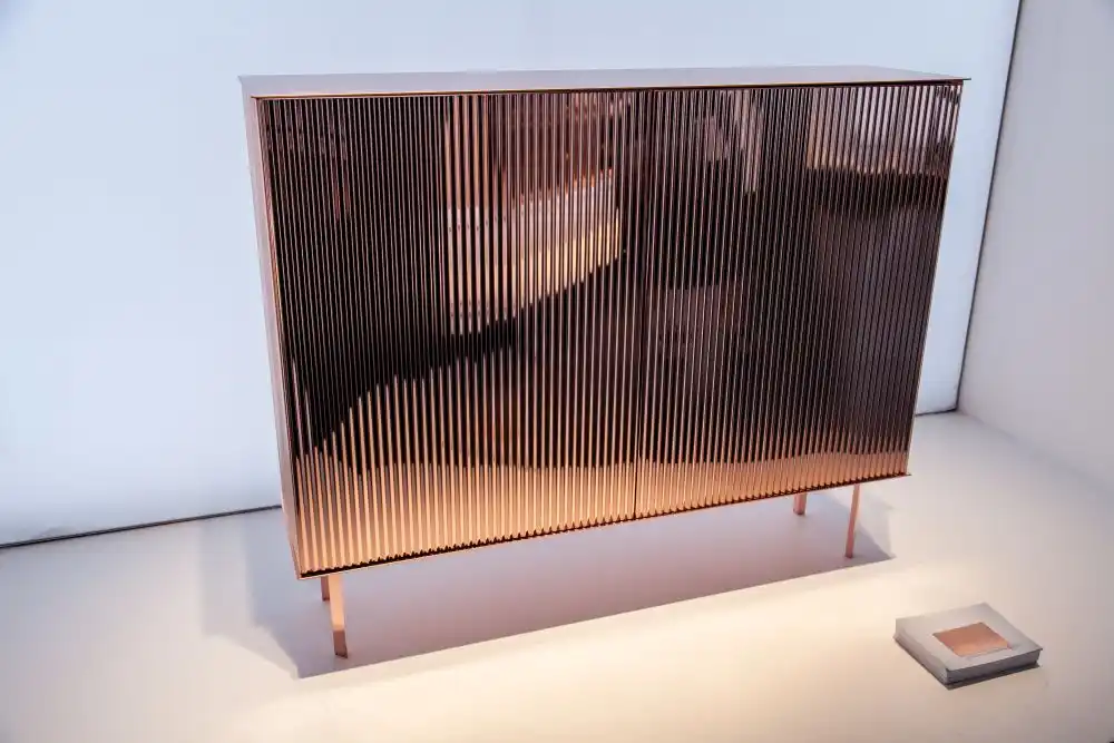 A small dresser with a polished copper finish