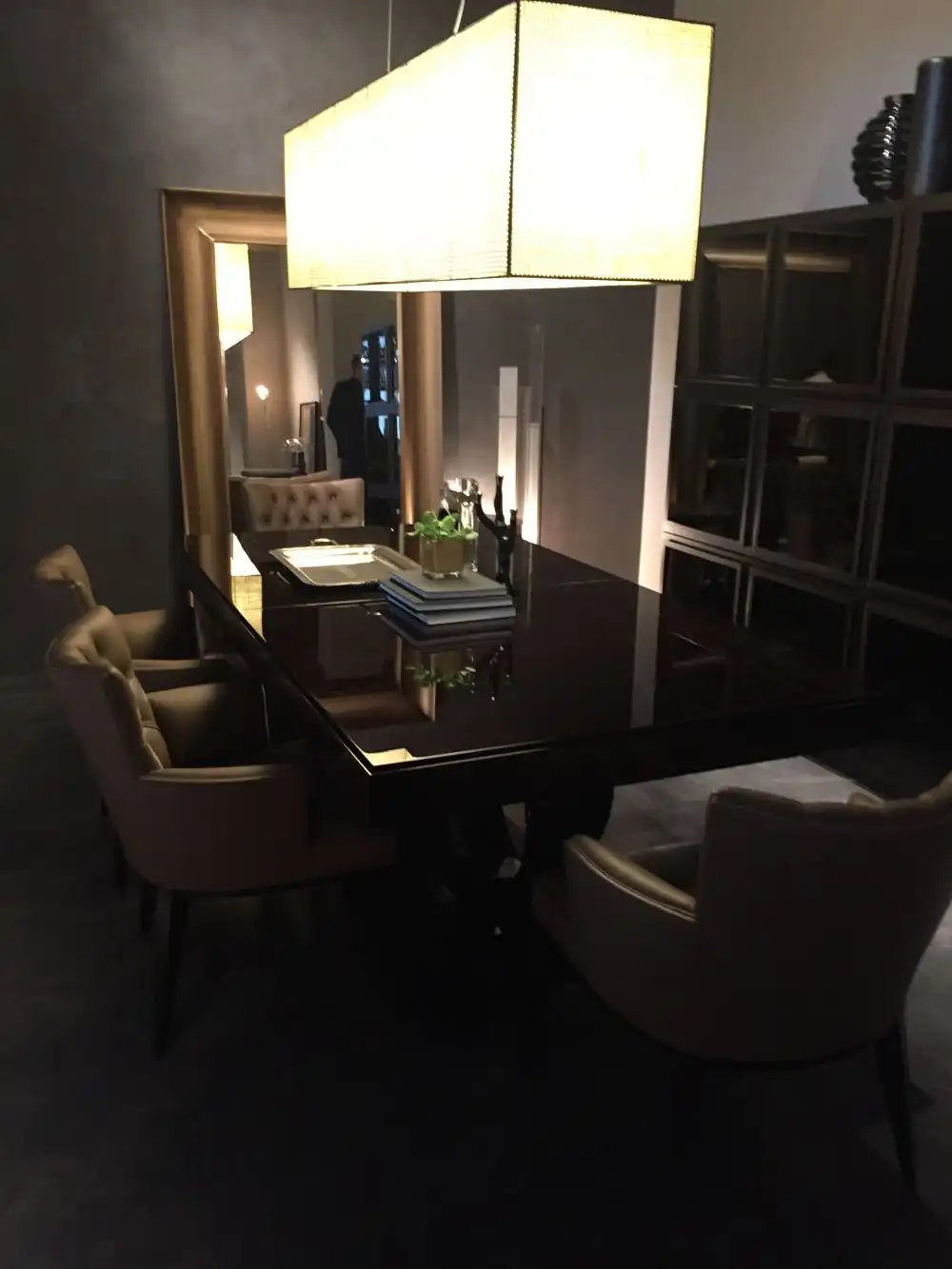 Dining room with large chandelier over table and rectangular floor mirror