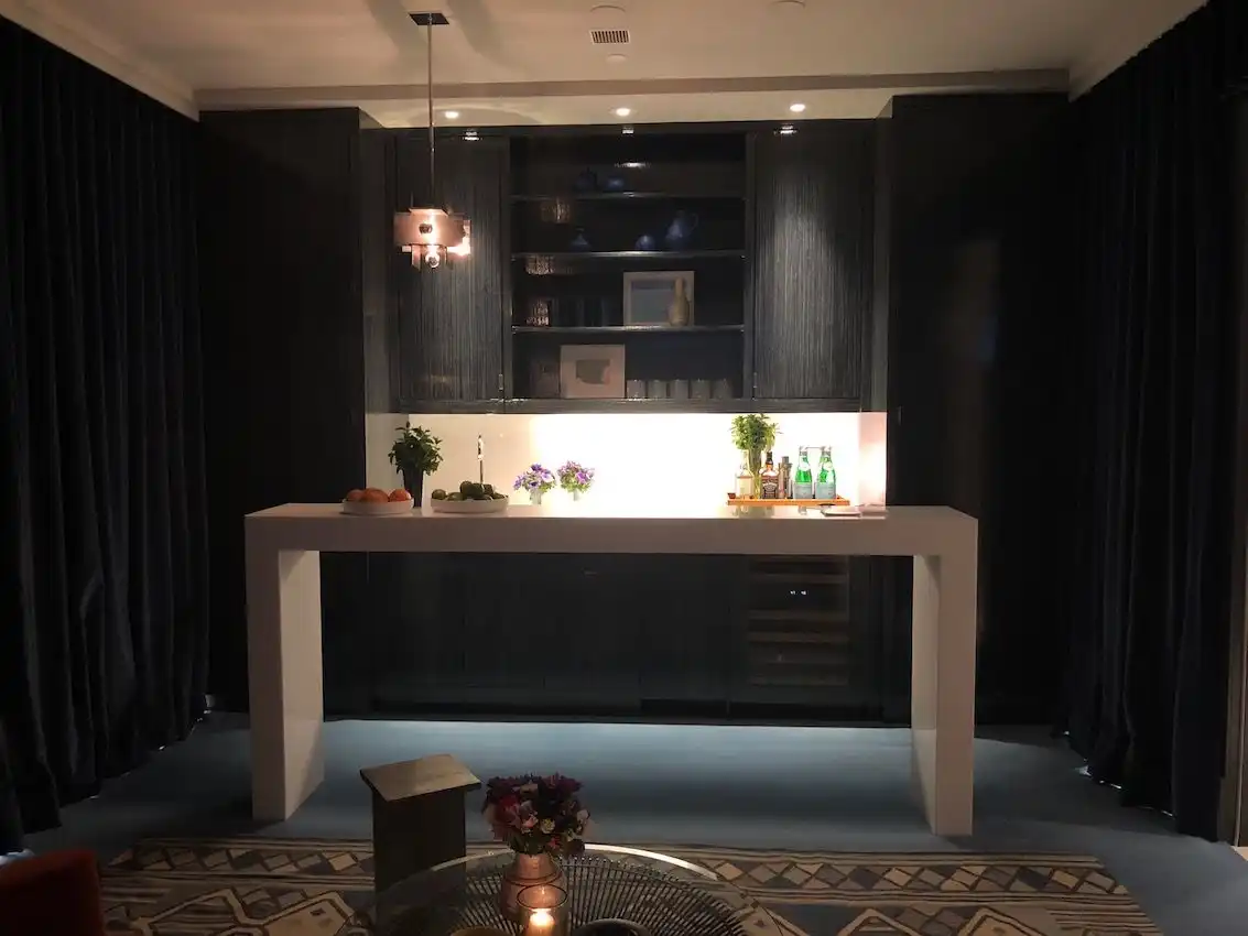 The dark, dramatic space is equipped with a bar sink.