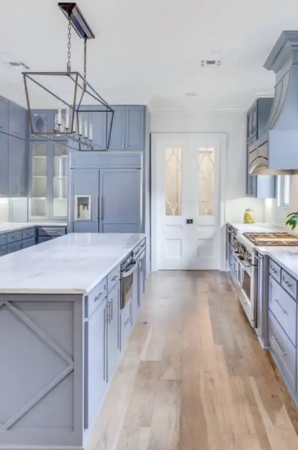 Elegant light wood floor and beige floor kitchen photo in New Orleans