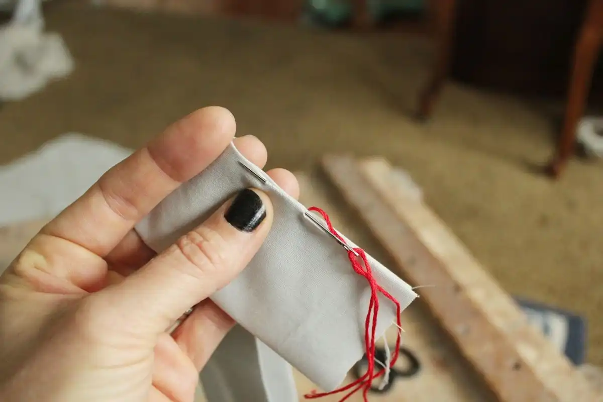 Exit the needle tip from the hem fold
