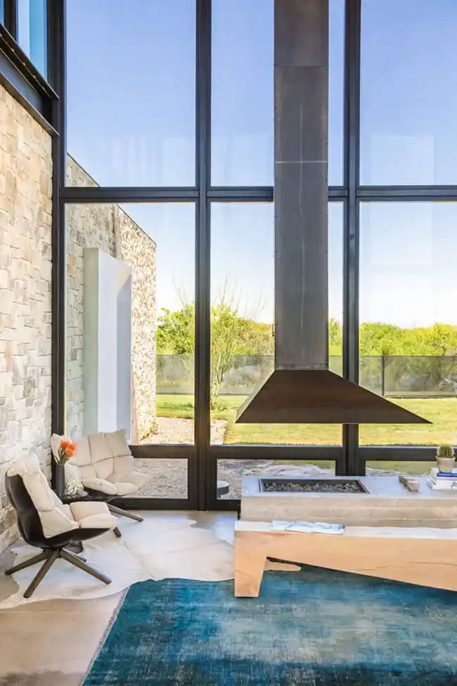 Fireplace in the center of the Living Room with large windows