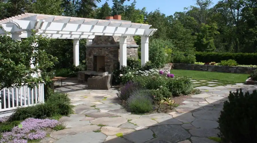 A flagstone patio can include flower beds or can be installed around the existing trees [Design from Rugo/ Raff Ltd. Architects ]