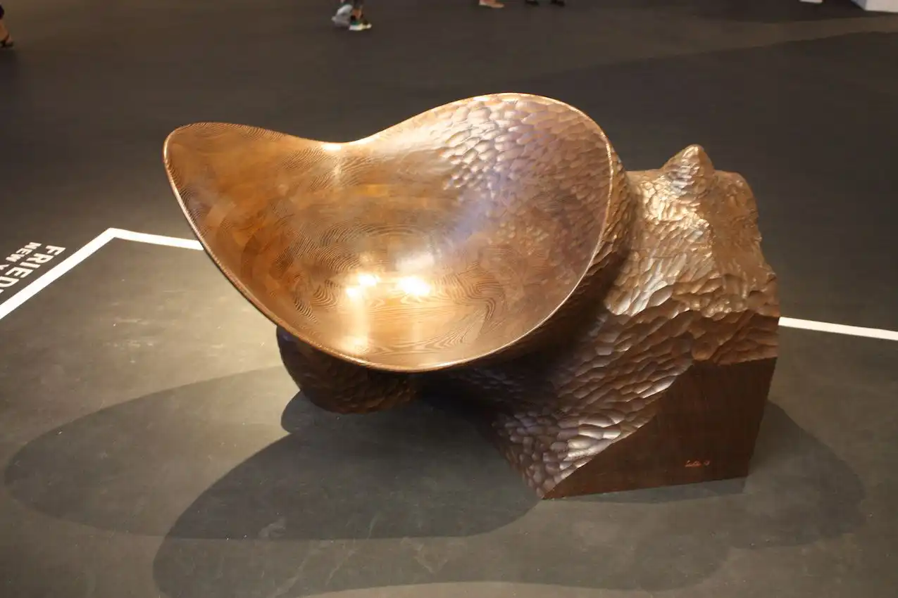 The piece is carved from stained ash wood.