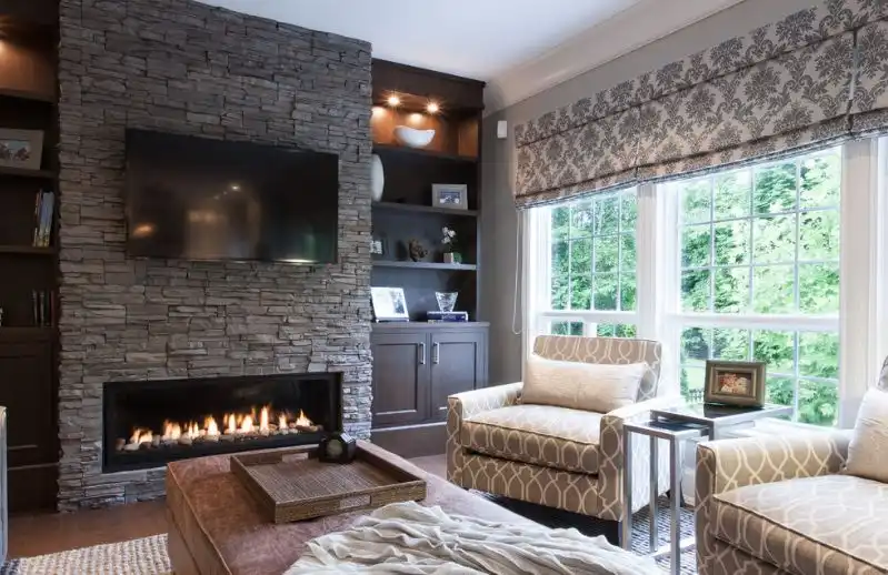 Grey stacked stone fireplace with tv above