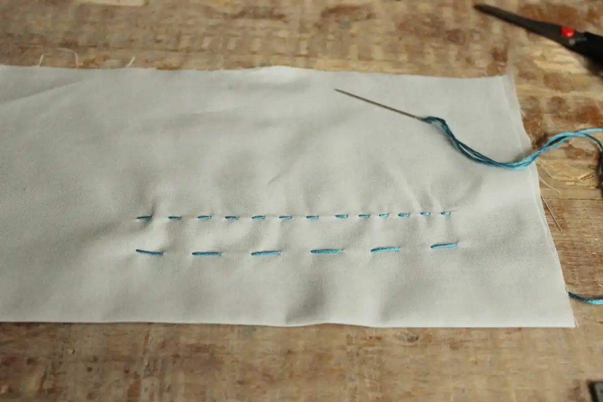 How to Sew - Pull the needle and thread through the fabric
