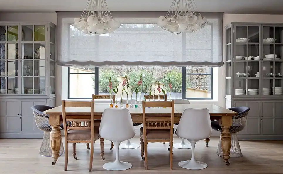 Large rectangular dining table with Saarinen tulip armchairs and classic chairs