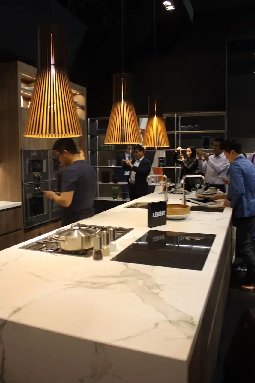 Leicht's use of these slatted kitchen lighting fixtures gives a warm look to the stone kitchen island.