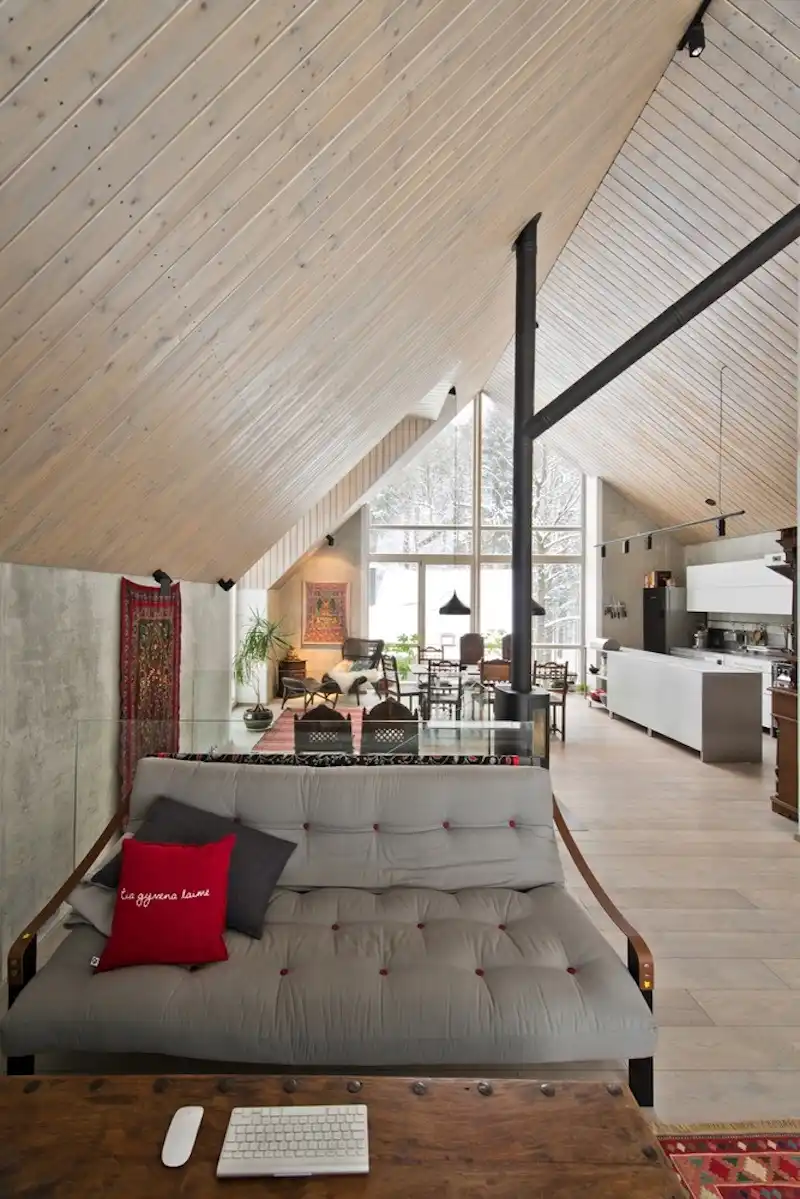 The care concrete walls are decorated with textiles and complemented by comfortable furniture