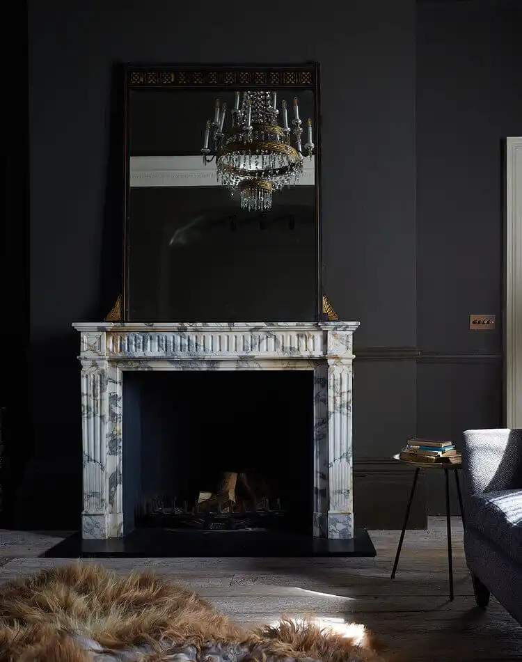 Living Room with fireplace and chandelier reflecting in the mirror