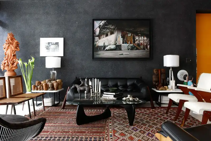 Living rom with a black wall and a mid century sofa