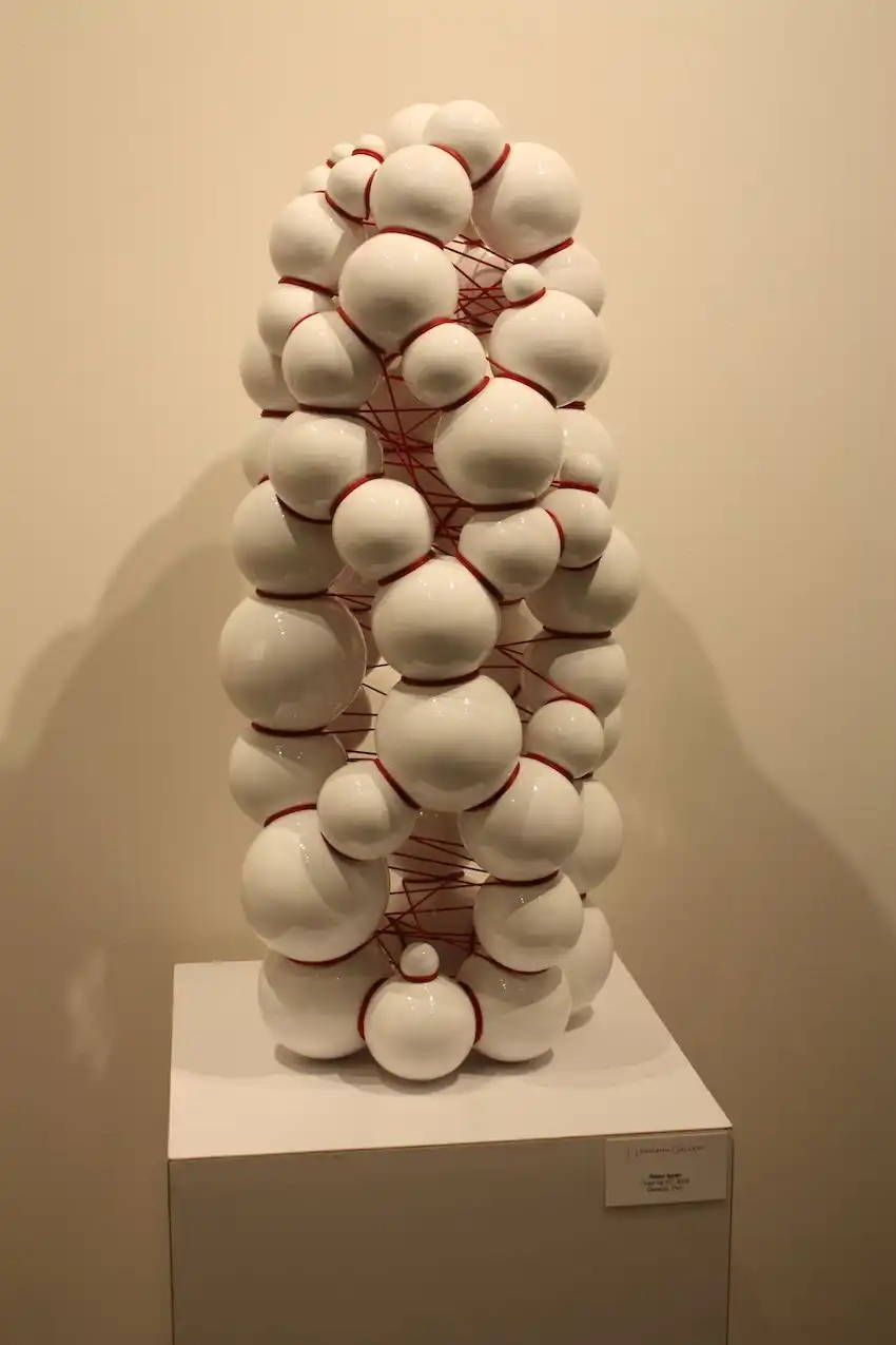 The red string seems to be restraining the ceramic figure from expanding.