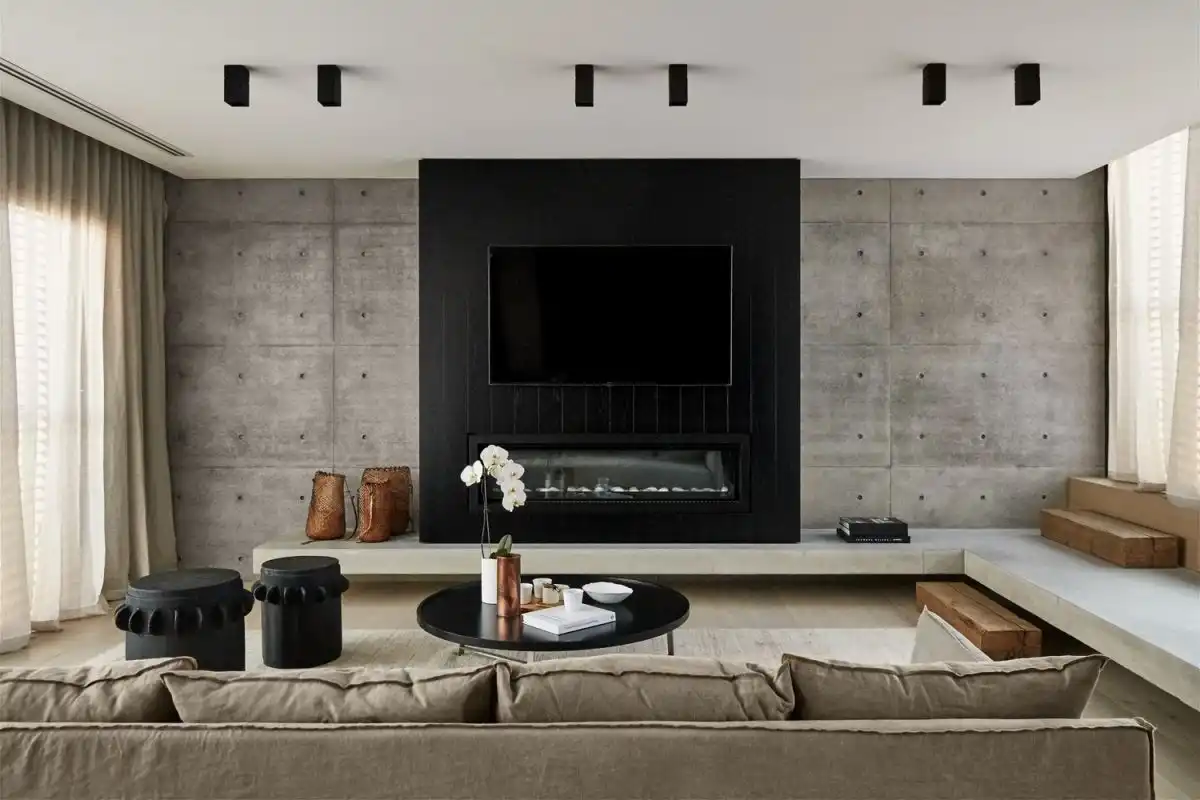 The minimalist formal living room has an industrial edge thanks to the concrete and ceiling lights.