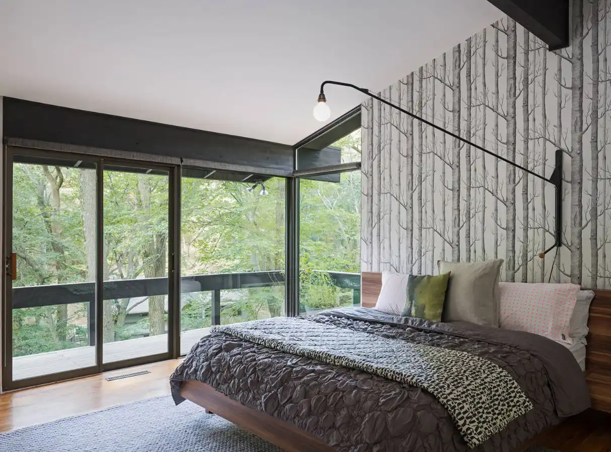 Modern bedroom with birch wallpaper and mid century bed