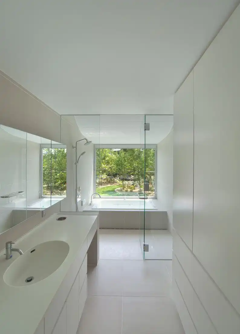 Narrow bathroom with white walls and large vanity sink