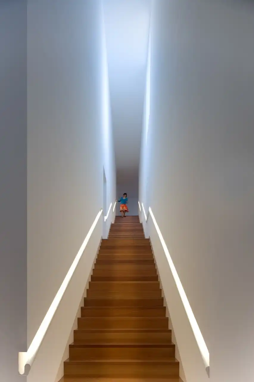 Narrow staircase with built in handrail and LED lights