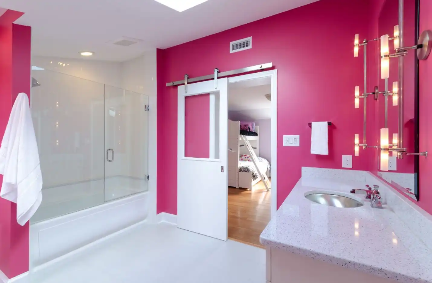 Pink bathroom decor with white barn door