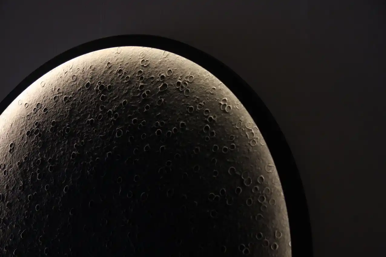 Hidden light sources push light into the center of the circle, reflecting off irregularities in the hand made paper.