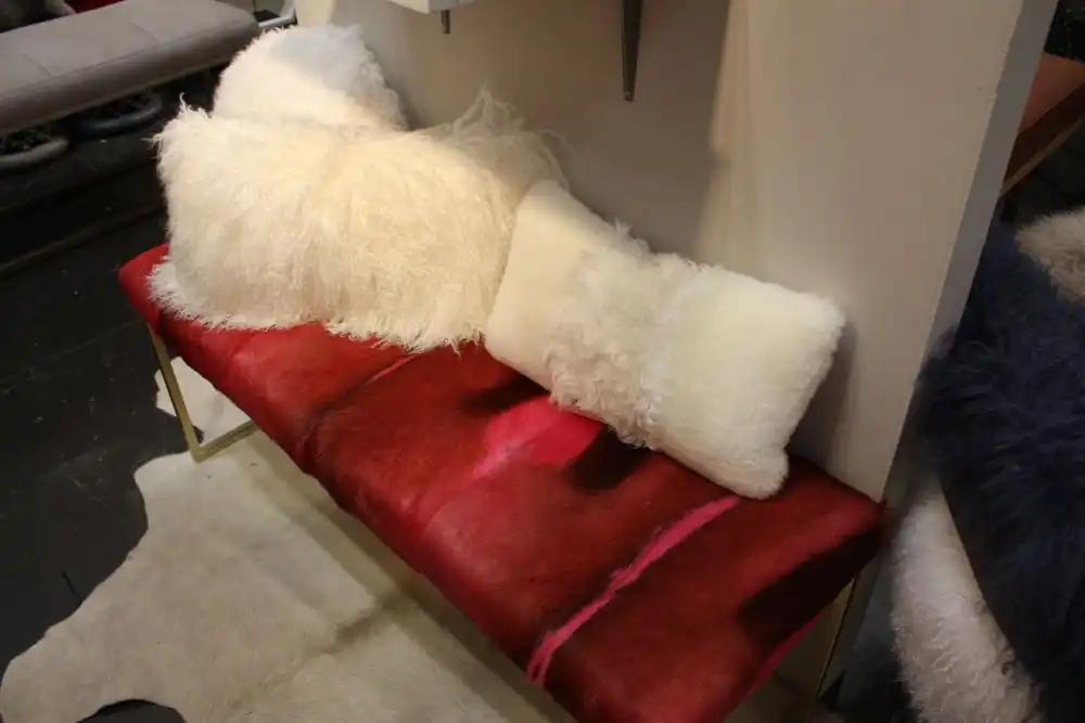 Red bench with gold base and fur pillows