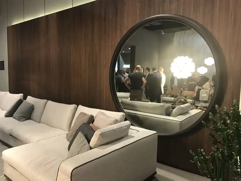 Round and large decorative mirror behind the sofa