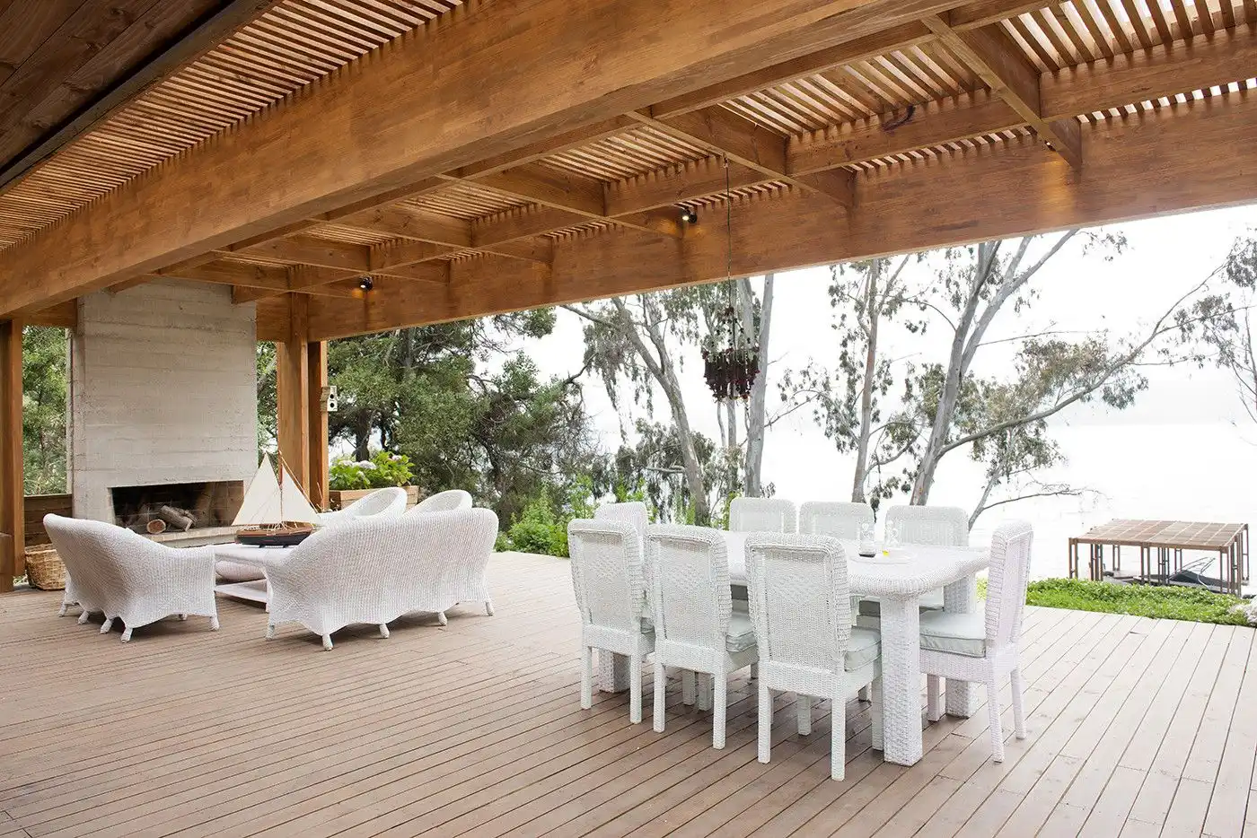 Solid wood pergola with wood beams and concrete fireplace
