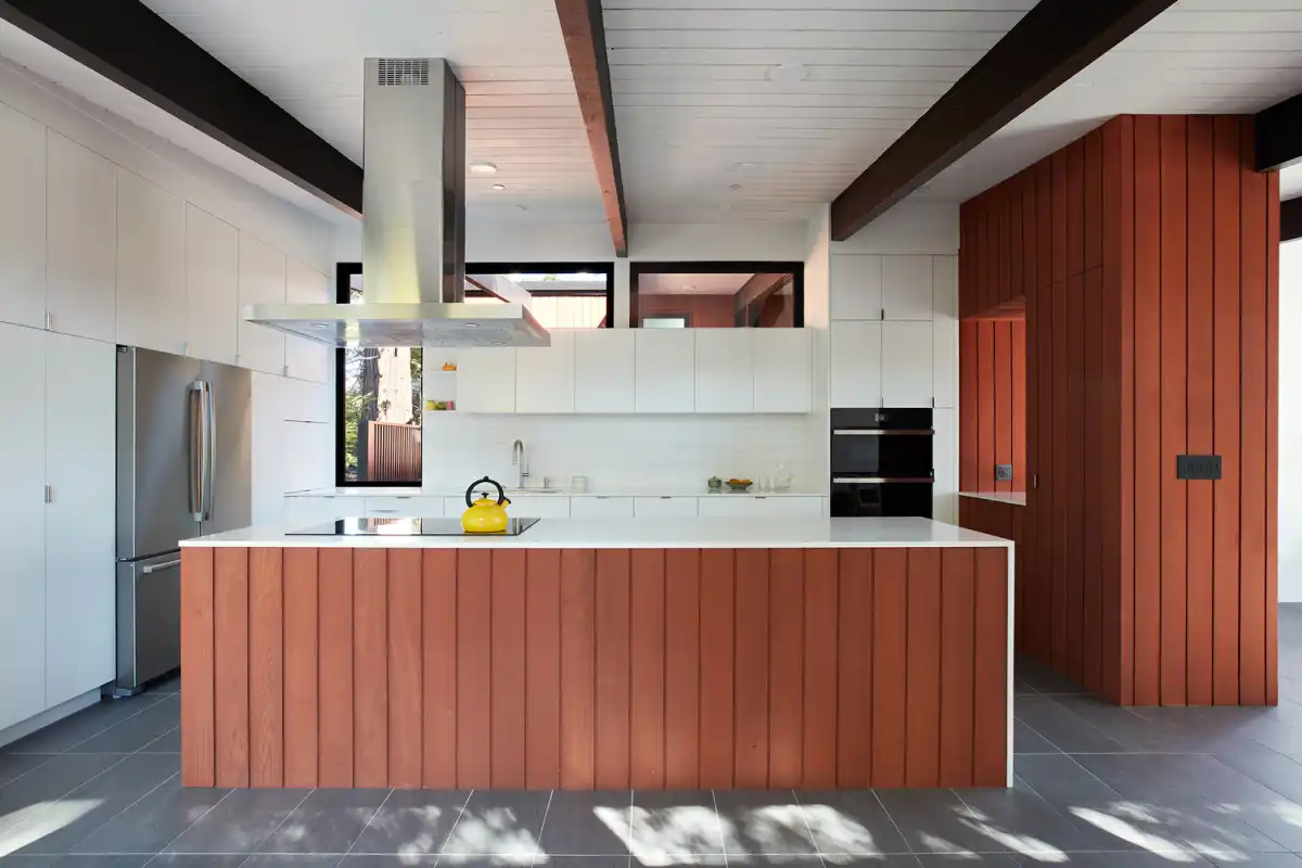 The kitchen island acts as a visual barrier and divider between the cooking area and the living spaces