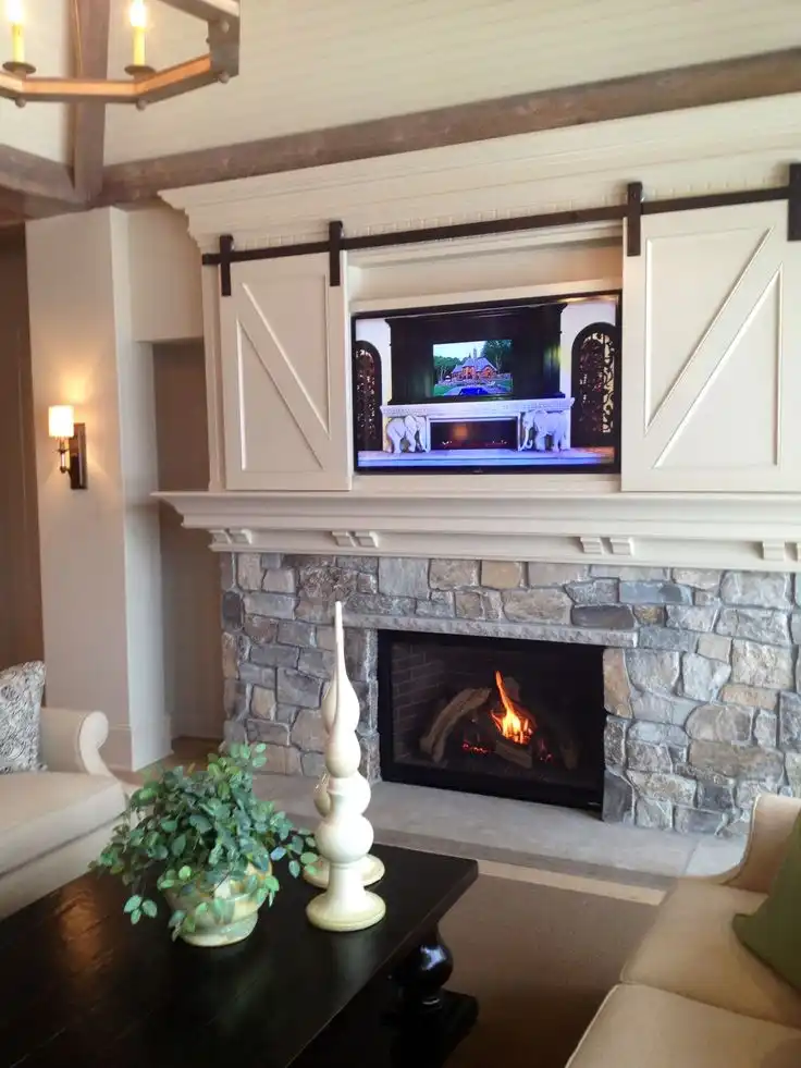 TV above the fireplace with miniature small barn doors