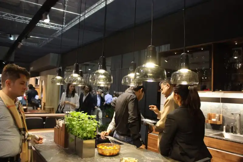 A veritable army of glass pendants serves as kitchen island lighting in this setting by Team7. If eight pendants is too many, a lesser number hung in a linear fashion would also work well.