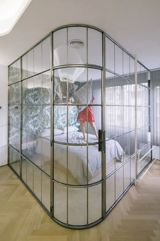 The bedroom is defined by the wall covering as well as the curved glass wall.