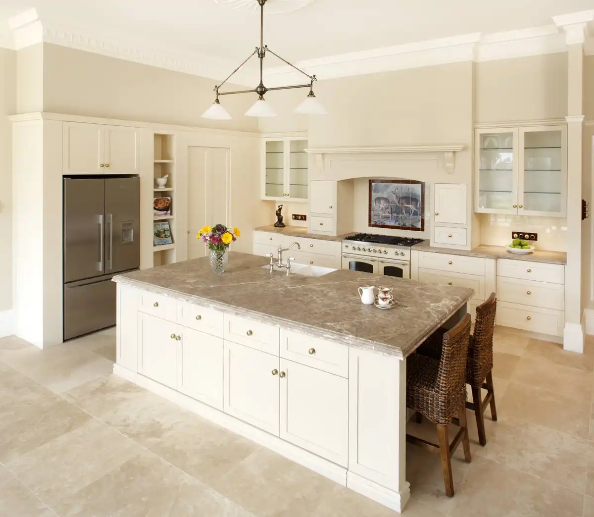 Traditional cream kitchen cabinets with island and travertine floor
