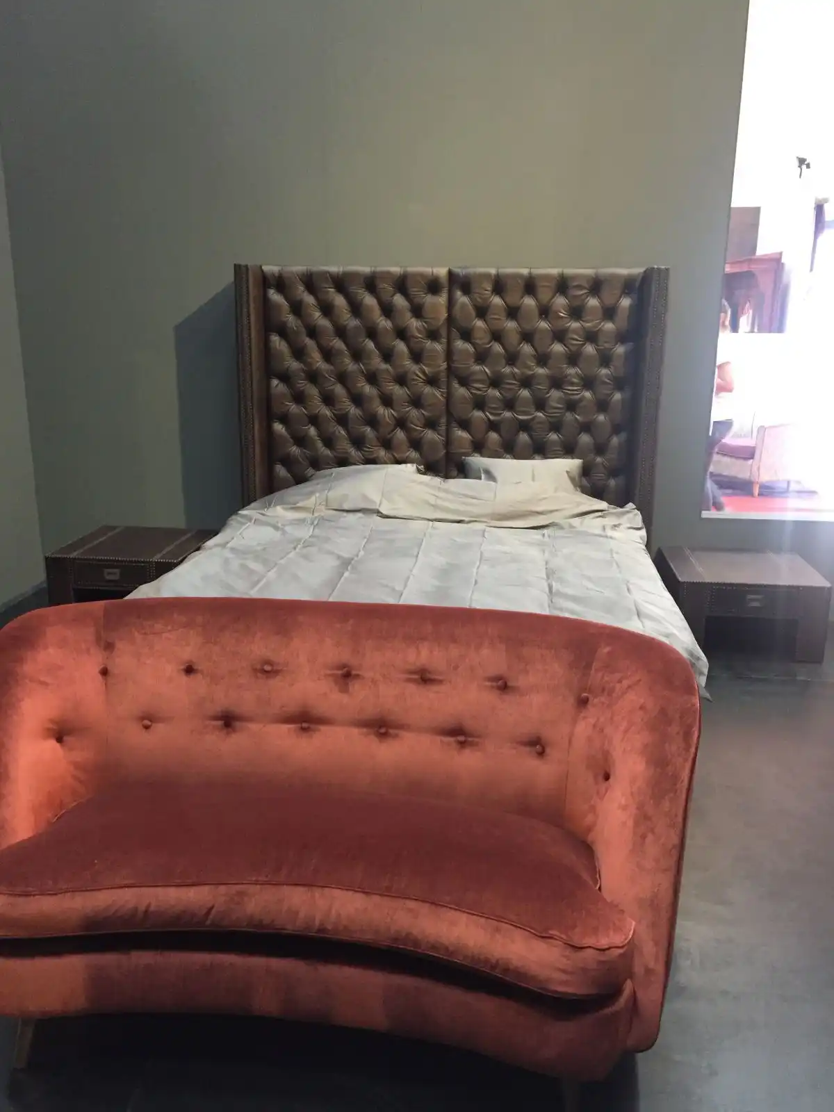 Tufted bed design with small couch on the bed footh