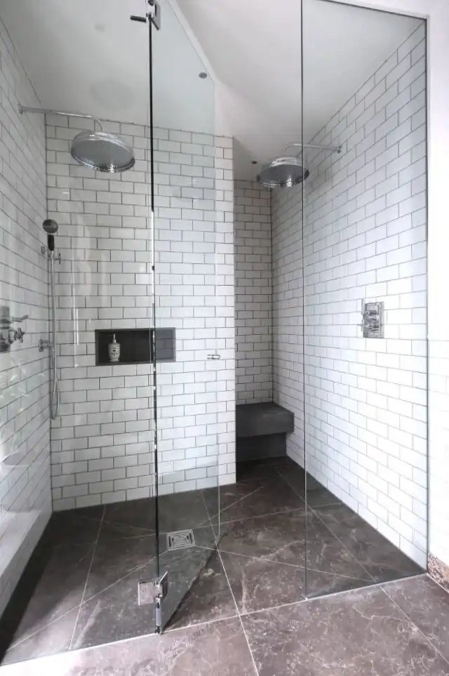 Walk in shower with subway tiles and storage niche