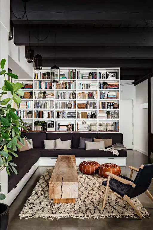 Wall shelves for books in living room and wood trunk coffee table