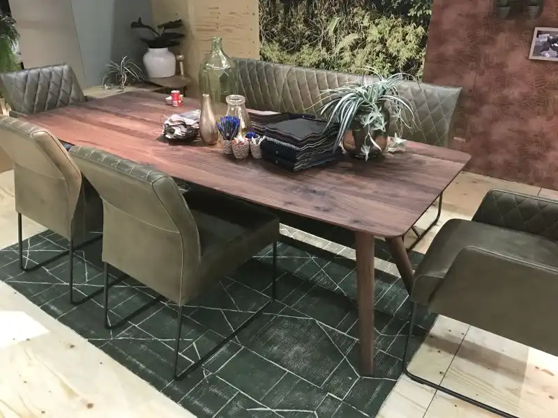 Walnut dining table with leather chairs and bench that has wire frame