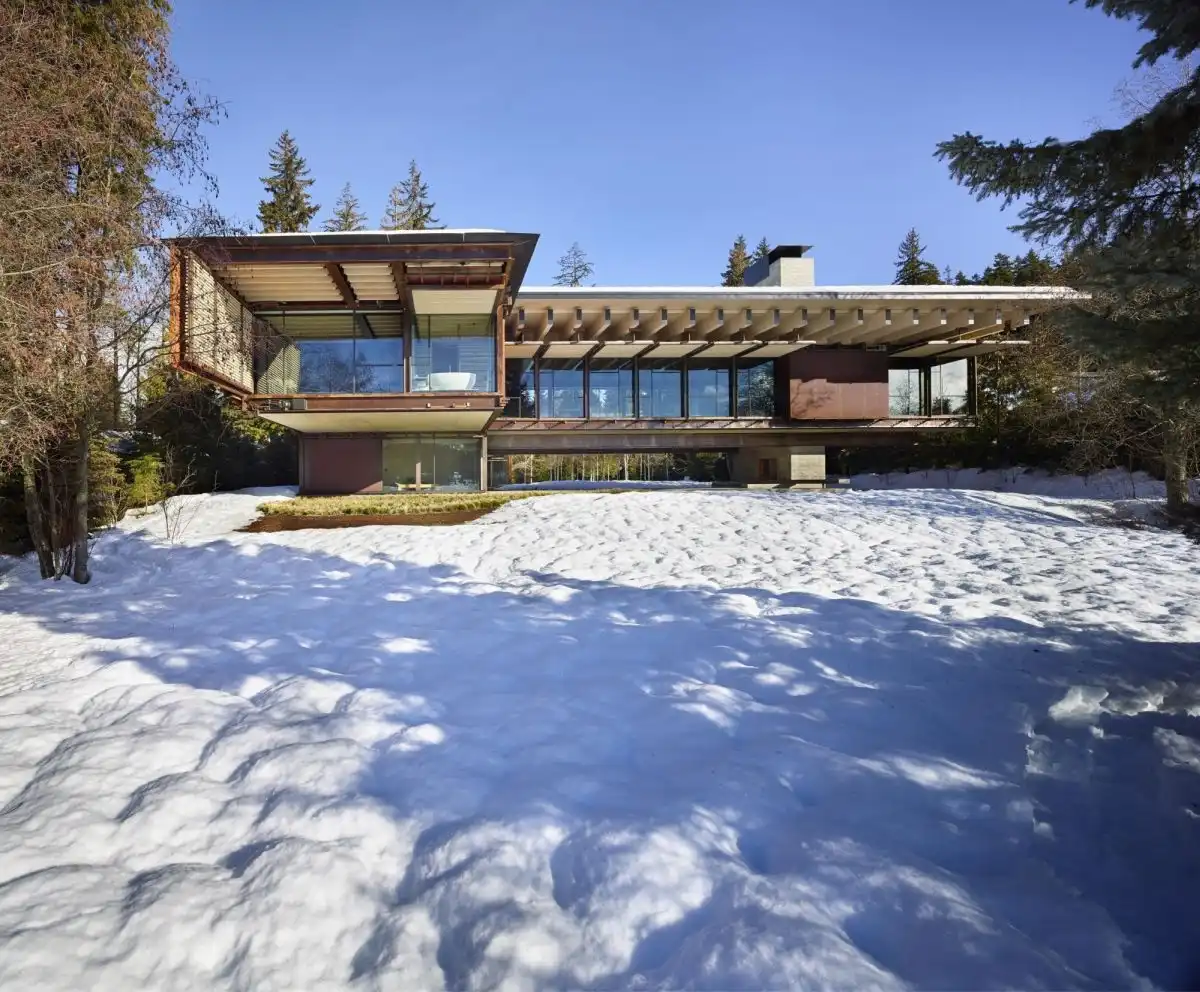 The house fits with the terrain and woods.