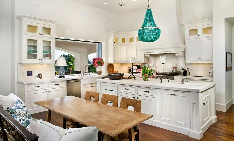 White kitchen with turquoise chandelier over island