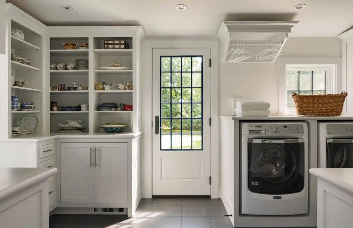 White laundry room design with storage areas